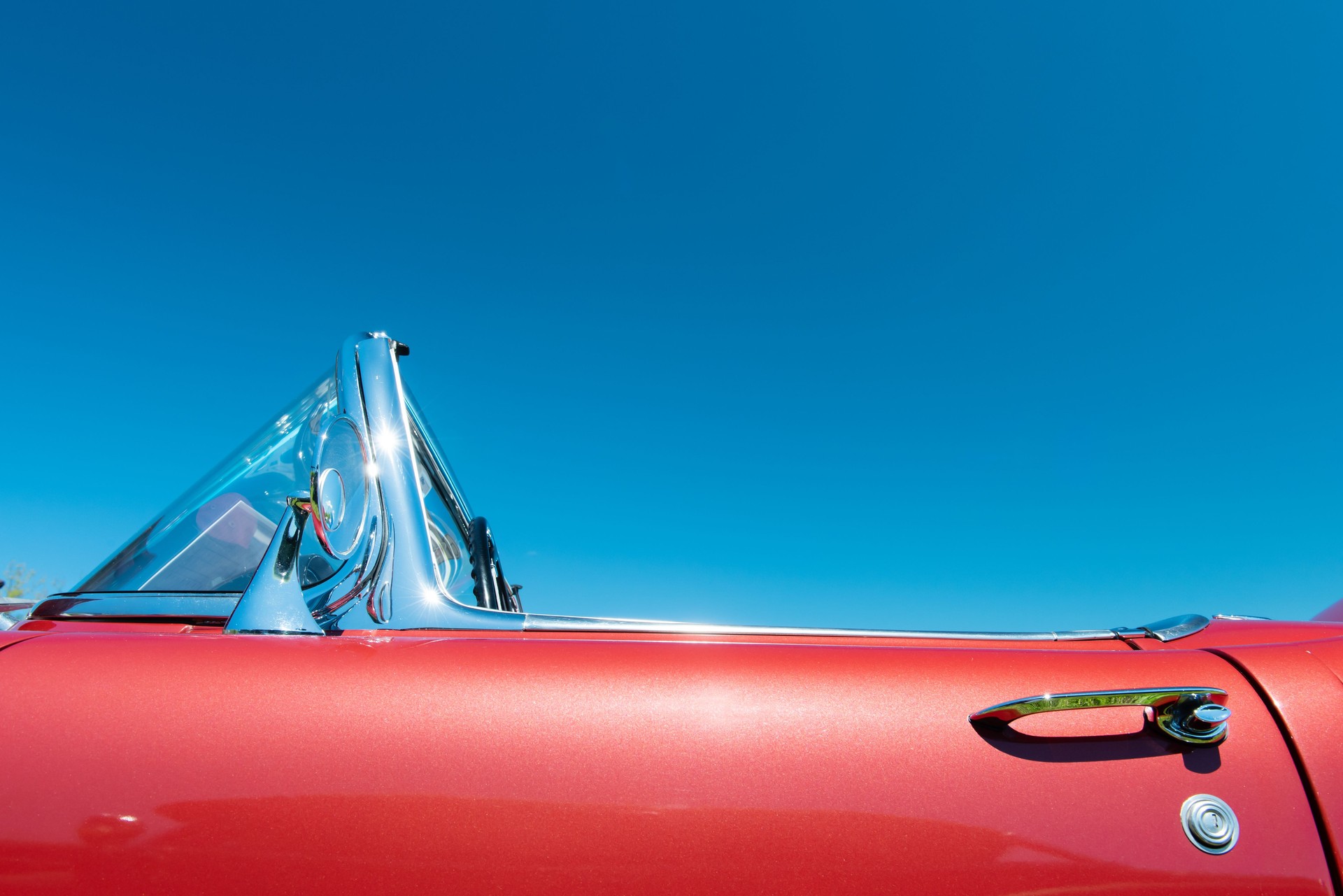 Red classic convertible car under a blue sky photograph